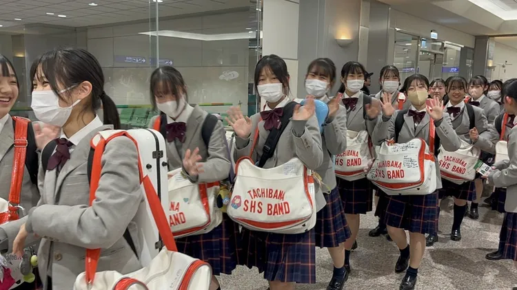 「橘色惡魔」團員們9日晚間搭機再度抵台，眾人身穿制服亮相，在桃園國際機場開心向接機人員揮手致意。中央社