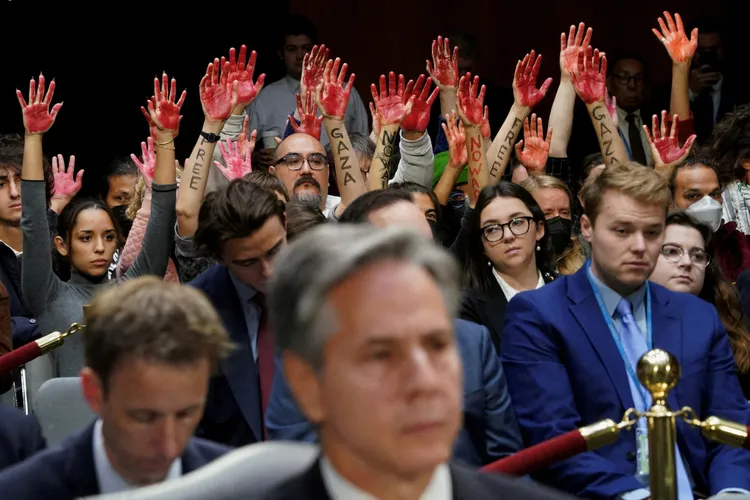 美國國務卿布林肯出席國會軍援烏克蘭與以色列的預算案聽證會，反戰人士高舉紅色手掌，聲援加薩民眾。路透社