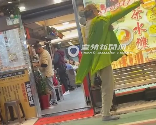 陳昇飽餐一頓後，穿起螢光綠外套，等紅粉知己幫忙買單。特勤中心攝