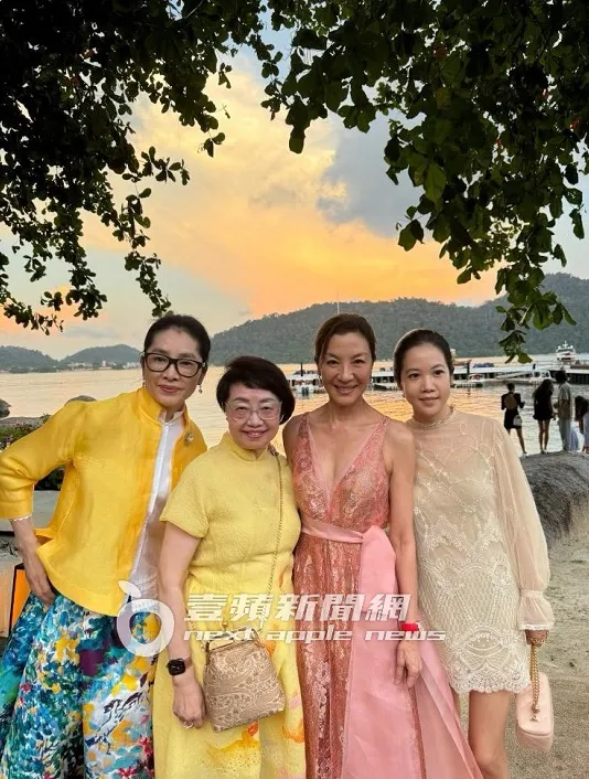 楊紫瓊與賓客在夕陽海景前合影。吳玉愛攝