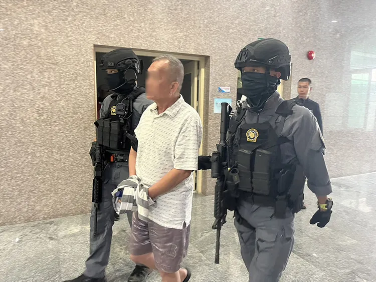 泰國警方逮捕擔任「第二包」的退役兩棲蛙人（中）。翻攝Thailand Police Department
