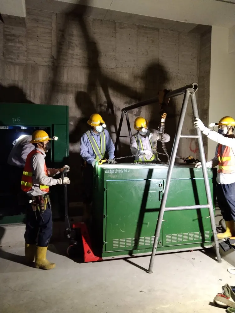 台電高雄區處施工課同仁於配電室以自製的A型吊掛設備將重量約1200公斤的四路自動化開關進行更換。台電提供