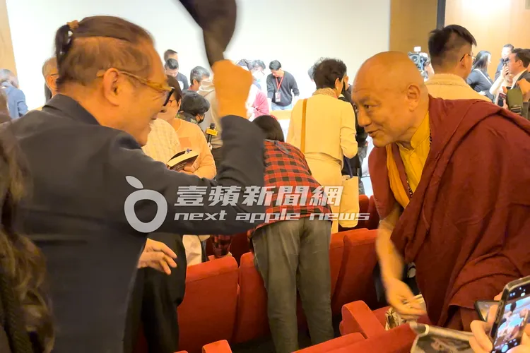 李連杰（左）會後脫下帽子，與台下嘉賓熱情打招呼。特勤中心攝