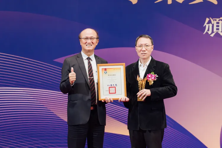 教育部次長林騰蛟(左)頒發「標竿圖書館獎」給高市圖代館長林奕成(右)。文化局提供