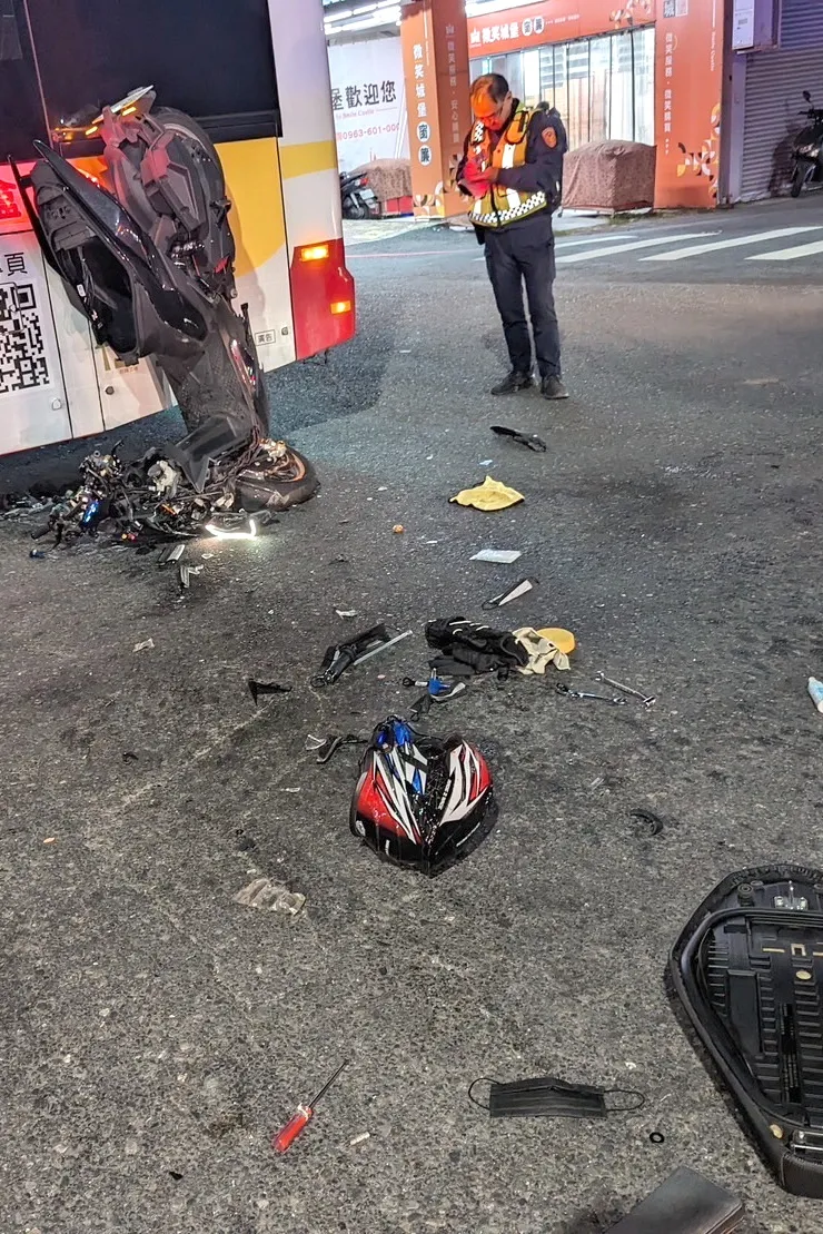 機車倒頭栽掛在公車上，零件散落一地，顯見衝擊力之大。讀者提供