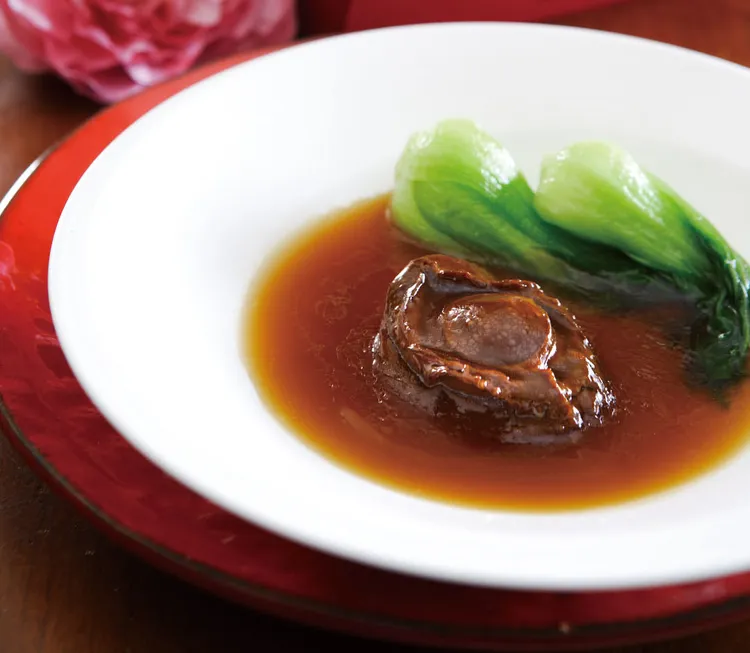 「極品蠔皇二頭鮑禮盒」嚴選色深肉厚的兩頭鮑以清水泡發六日，加入後腿肉及老母雞熬煮的鮮甜高湯，紅燒扣燉至色澤油潤、口感柔軟紮實。潮品集潮州料理餐廳提供