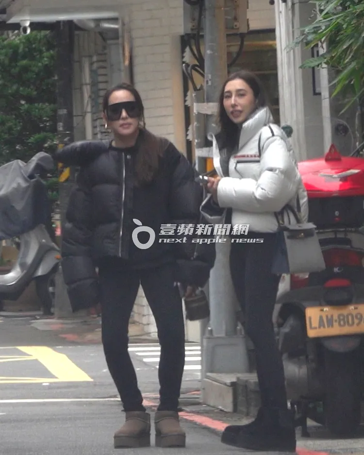 寒流來襲，石貞善（左）手拿售價約3萬6千元的LV化妝包等車，冷到頻頻抖腳，看起來像在跳舞。特勤中心攝
