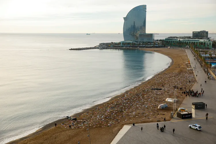 巴塞隆納聖賽巴斯提安海灘景色優美，人權組織用破布、鞋子布置出船難景象。路透社