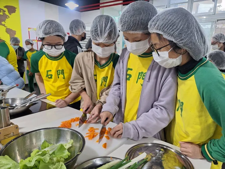 學生們大展身手烹調營養午餐。教育局提供