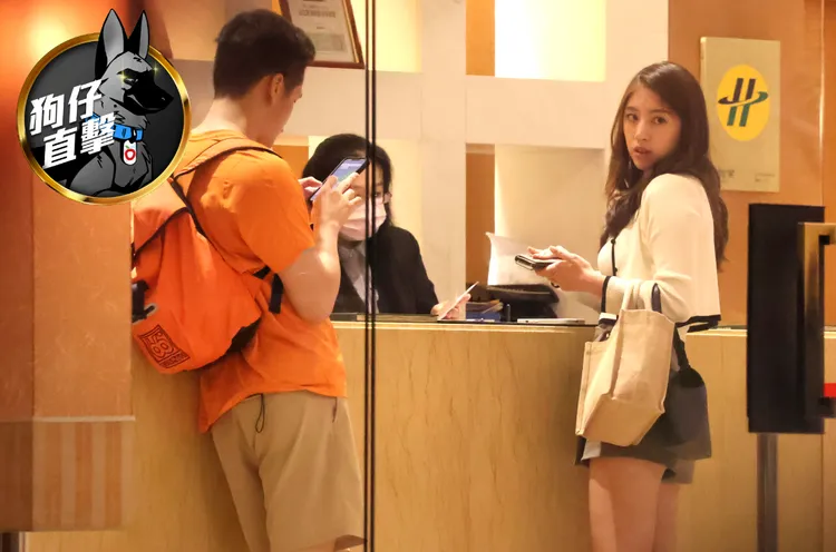 辜莞允（右）在櫃檯交證件，辦理入住手續付泡湯費，男友則在旁爽滑手機。特勤中心攝
