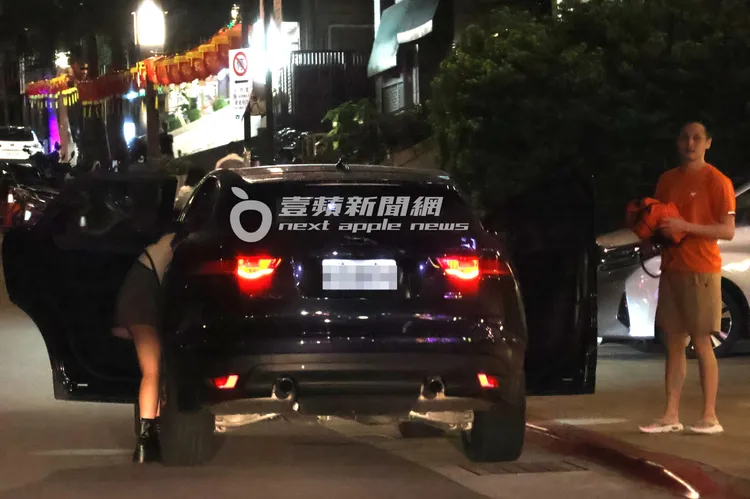 辜莞允（左）趴進車內整理行李，男友在一旁等待。特勤中心攝