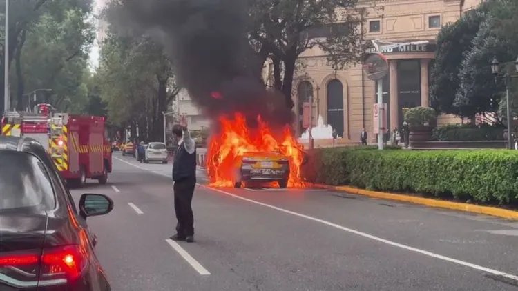 計程車燒成火球，文華東方的警衛在旁戒備。翻攝畫面