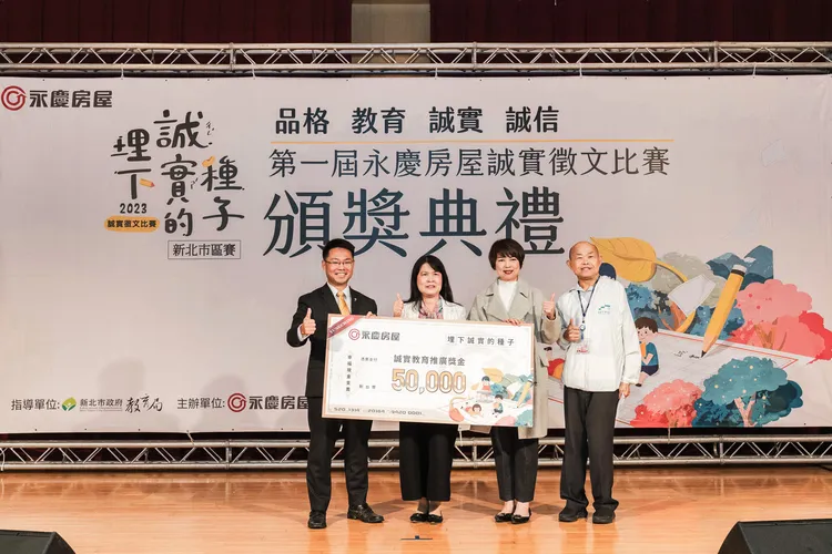 永慶房屋副總經理黃俊傑(左1)，在新北市政府副秘書長龔雅雯(右2)、新北市教育局副局長歐人豪(右1)的見證下，贈與5萬元的「誠實教育推廣獎學金」。永慶房產集團提供