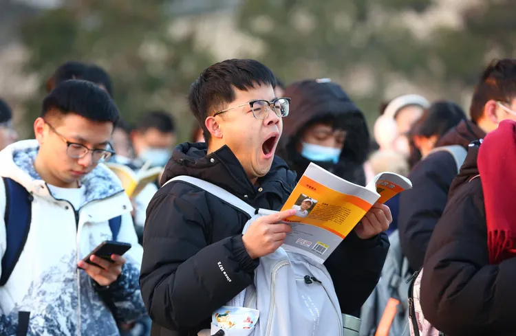 一名考生今天在山東棗莊的考場外複習。新華社