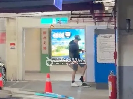 洪天祥一手扶著繳費機，把原本穿在腳上的白色球鞋換上黑色球鞋。特勤中心攝