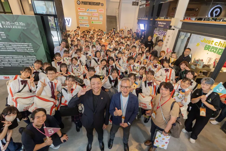 青年局長張以理 (中間左一)、橘高校前理事長梅本裕先生與橘高校吹奏樂部同學們於Pinway駁二8號倉庫大合照。青年局提供