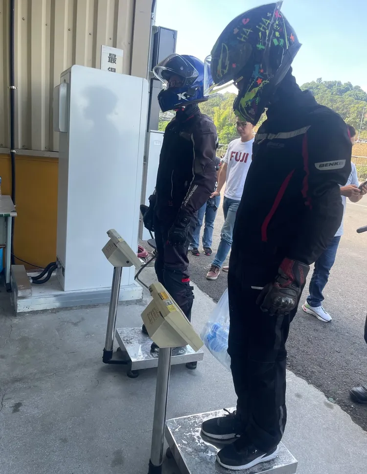 在兩台磅秤的測量下，兩車手的體重差必須用礦泉水來彌補。林浩昇攝
