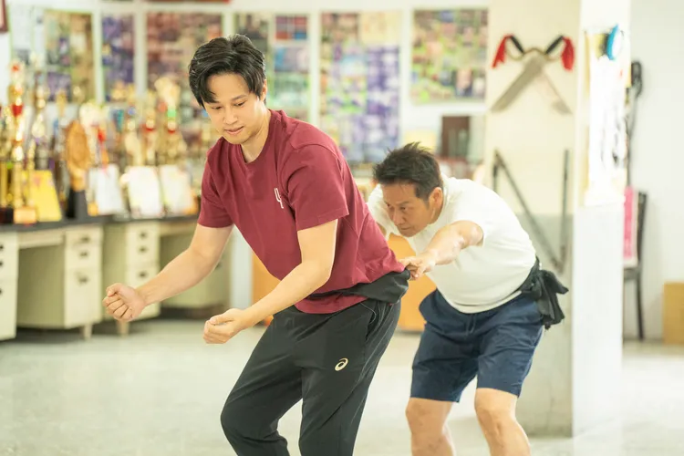 體驗「舞獅」，徐新洋（前）不忍心徐乃麟太累。民視提供