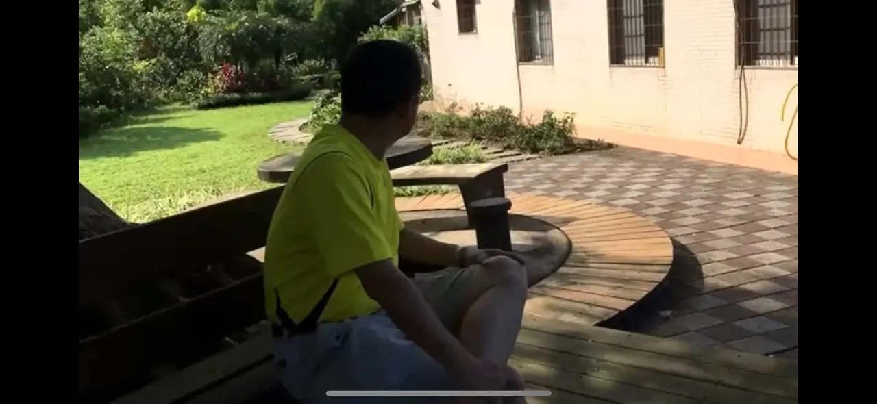 鄉民轉發截圖說,屋旁的樹下有造景乘涼的桌椅。賴清德萬里老家實景影片截圖,翻攝自論壇PTT