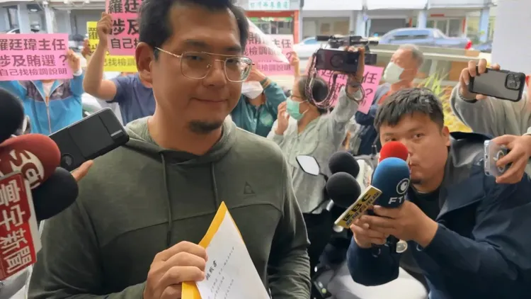 江肇國服務處人員則在後方舉海報反制，要石國勳到地檢署說明。羅廷瑋服務處提供