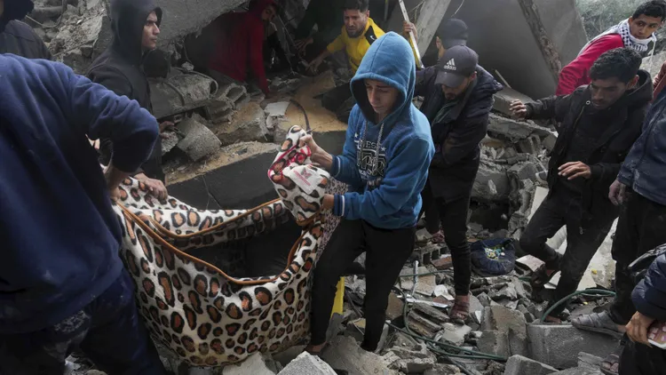 以色列強力轟炸加薩民宅，民眾從瓦礫中抬出罹難者遺體。路透社
