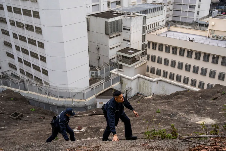 香港荔枝角拘留所外，警員爬上高處巡邏。美聯社