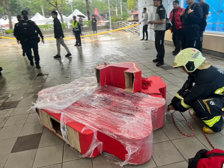 造景看板於板橋捷運站手扶梯入口處卡住天花板，消防隊將其拆除卸下。翻攝畫面
