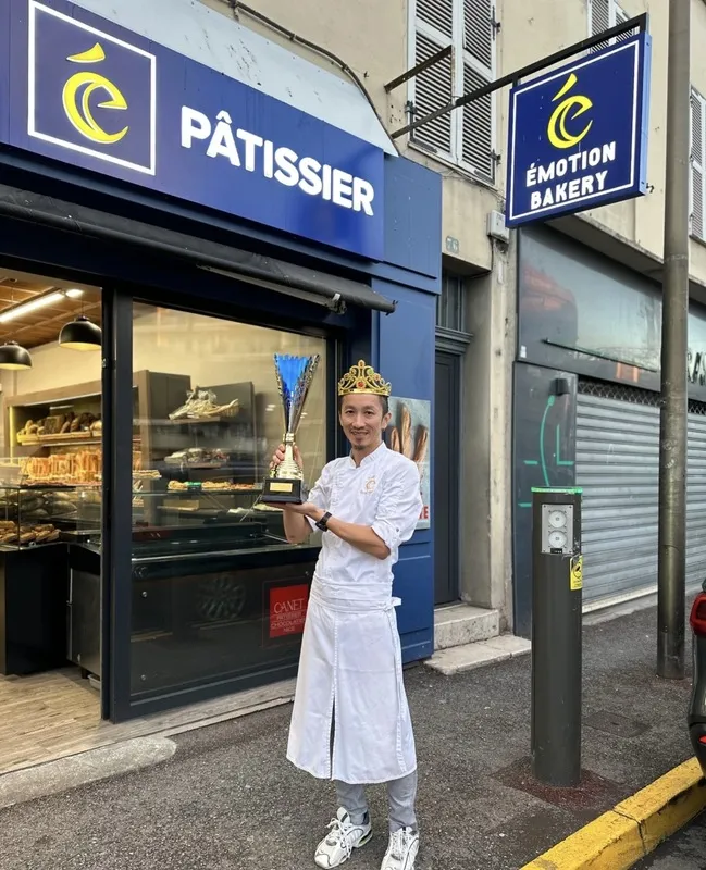 法國省級國王派大賽冠軍艾力克徐在自家麵包店前手捧冠軍獎盃。（艾力克徐提供）中央社