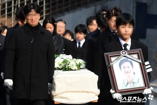 李善均的長子捧著遺照。翻攝xportsnews