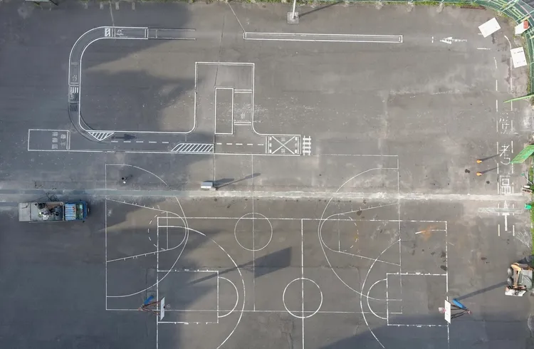 林口區忠孝路機車練習場工程改善前，機車練習場與籃球場容易互相影響。公所提供