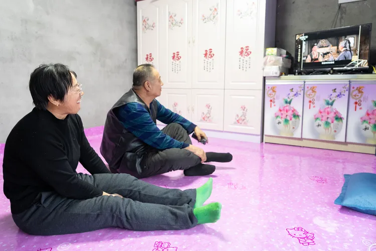 中國黑龍江尚志一對夫妻在家中看電視。新華社