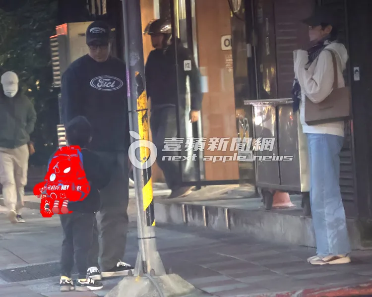 張孝全和兒子在路邊講話，家中長輩裹著圍巾包緊緊，從巷內步出。特勤中心攝