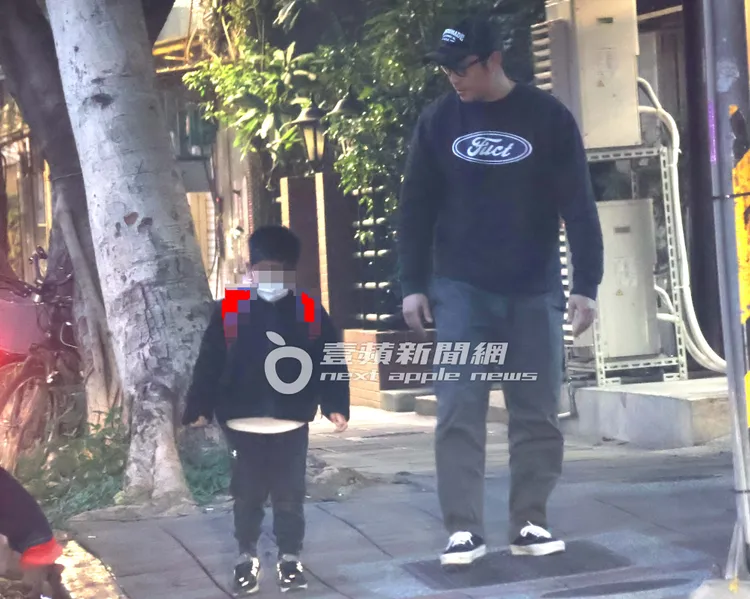 張孝全兒子背著卡通圖案的後背包在路旁和爸爸聊天。特勤中心攝