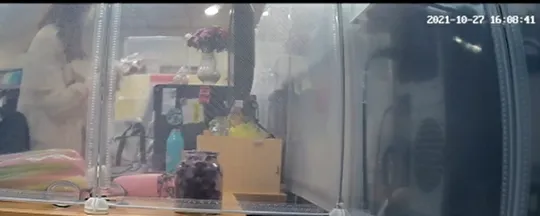 張靖玲戴手套拿起電腦主機上水晶以衛生紙擦拭水晶底部。翻攝判決書