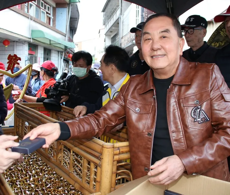 南投縣竹山紫南宮1日發送甲辰龍年招財錢母，吸引約10萬人排隊領取，竹山紫南宮主任委員莊秋安（右）親自發給信眾。
中央社