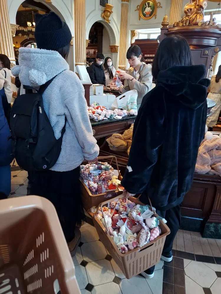 結帳櫃檯前，中國黃牛手上的購物籃滿滿都是限定版達菲，令其他遊客為之氣結。翻攝X