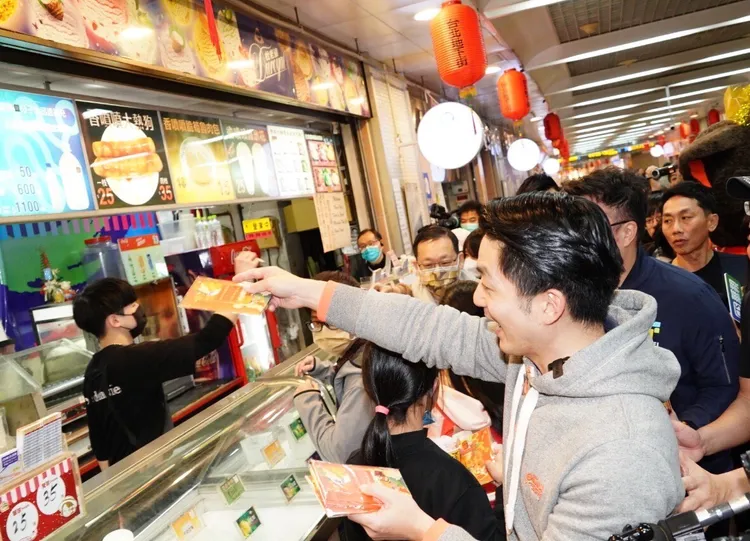 台北市長蔣萬安今日出席2024後華地商圈年貨大街走街活動，發送發財金。北市府提供