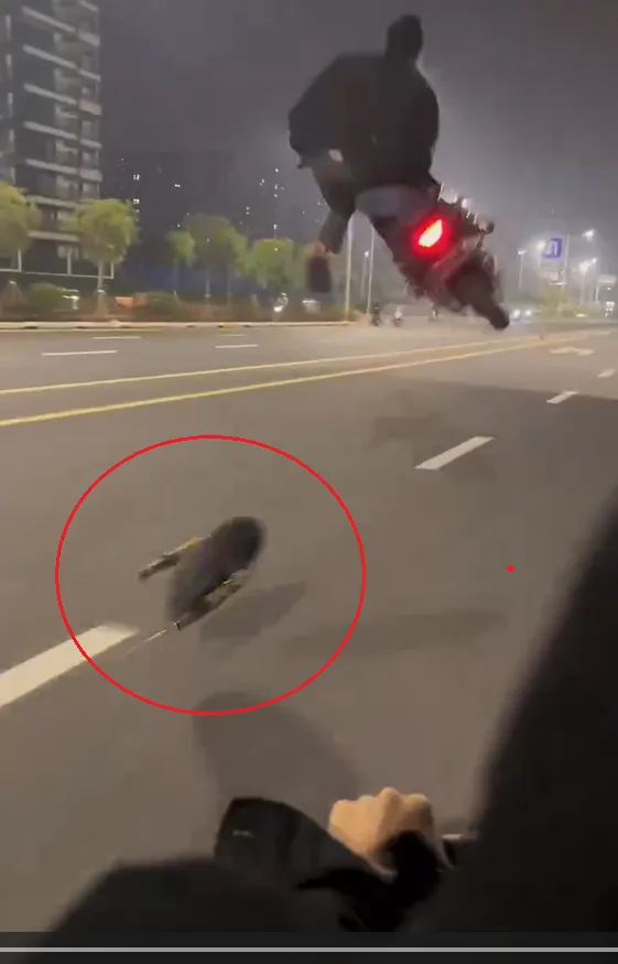 機車的前輪跟部分零件脫落，「托孤輪」的男騎士自己輾過後高高飛起。翻攝自記者爆料網