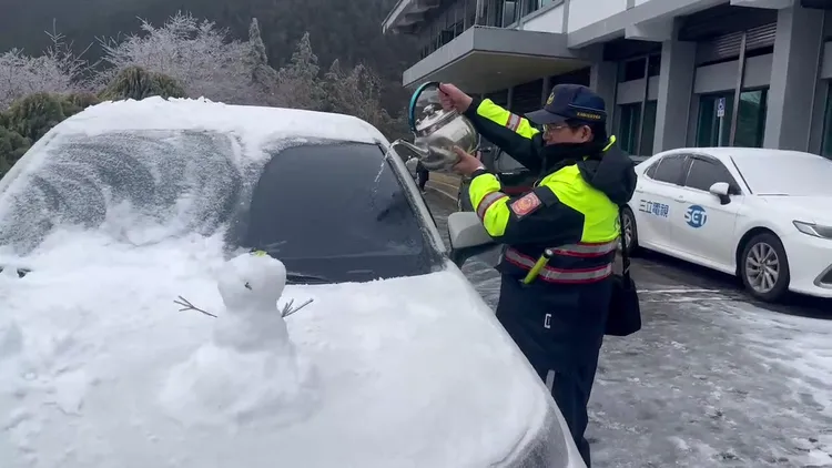 宜蘭警方用熱水融化覆蓋在車輛上的白雪，方便遊客安全開車離去。翻攝畫面