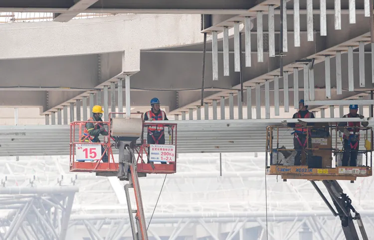 工人今天搭乘登高作業車，在中國重慶科學會堂施工。新華社