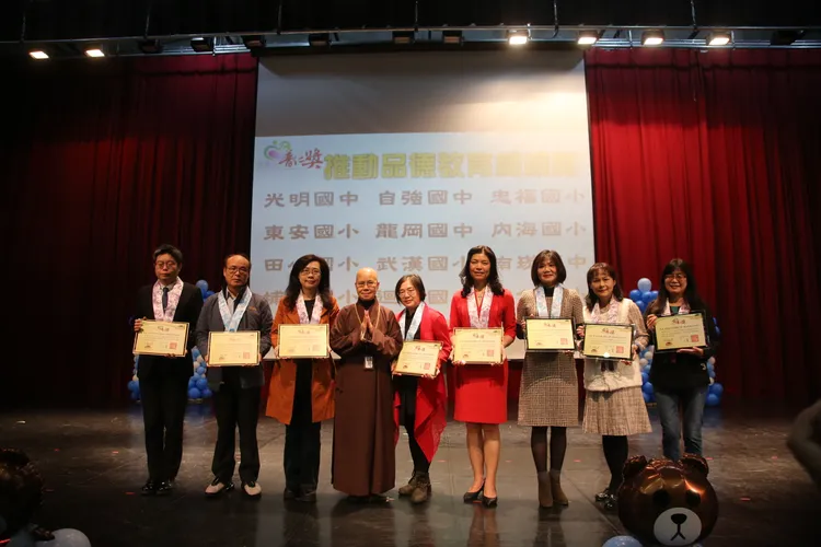 靈鷲山慈善基金會董事長性月法師頒發「推動品德教育楷模獎」給得獎學校。靈鷲山佛教教團提供