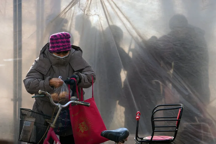5日北京一傳統市場旁，一名長者剛買了一袋馬鈴薯。美聯社