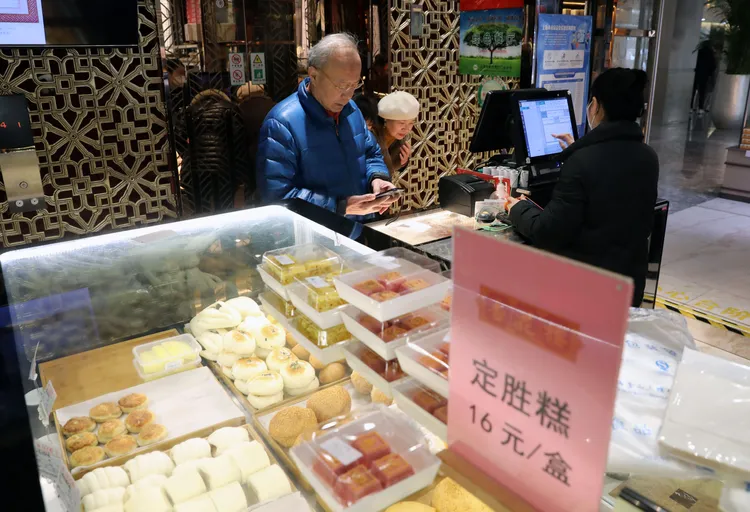 民眾在黃河路老字號點心店「杏花樓」，選購劇中人曾吃過的定勝糕。新華社