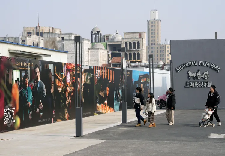 遊客在上海影視樂園（車墩影視基地）看著《繁花》海報。新華社