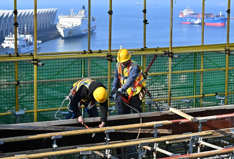 中鐵建工的工人在山東青島國際郵輪港區航運中心工地工作。新華社