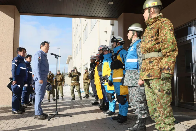 日本首相岸田文雄（左）視察救援部隊。美聯社