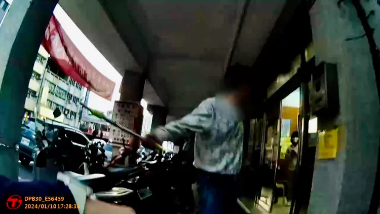 沈嫌揮舞鐵棍不願就範。讀者提供