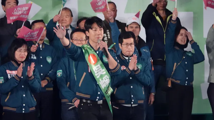 民進黨立委候選人吳崢致詞時自爆發燒吊點滴。彭欣偉攝