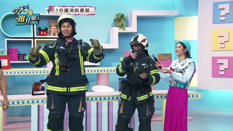 風田（左）挑戰1分鐘內快速著裝20公消防裝備，直呼當消防員不容易。年代提供