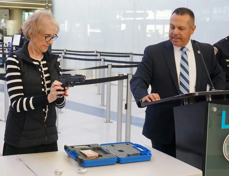 美國運輸安全管理局（TSA）聯邦安全主任潘塔吉斯（右）10日在機場大廳的記者會上，示範托運槍枝的方式。中央社